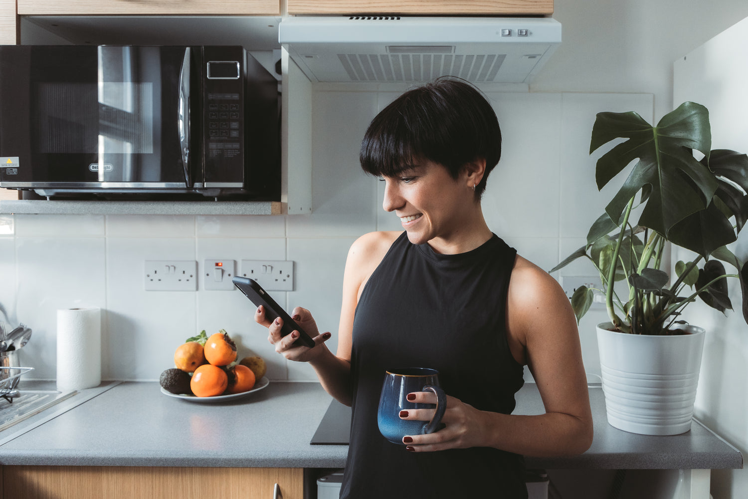 woman using her phone in the kitchen